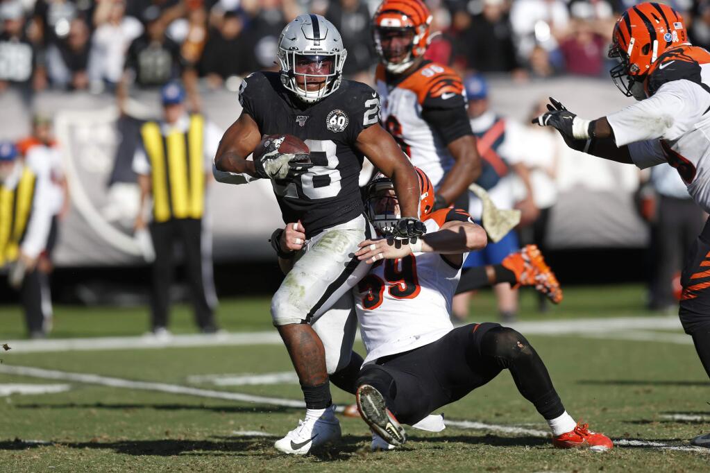 In this Nov. 17, 2019, file photo, Oakland Raiders running back Josh Jacobs runs with the ball away from Cincinnati Bengals outside linebacker Nick Vigil during the first half in Oakland. (AP Photo/D. Ross Cameron, File)