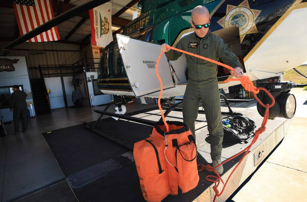 Tactical flight officer Chris Haas makes routine checks to the Sonoma County Sheriff's helicopter Henry 1 rescue lines, Monday, Feb. 24, 2020. (Kent Porter/ The Press Democrat)