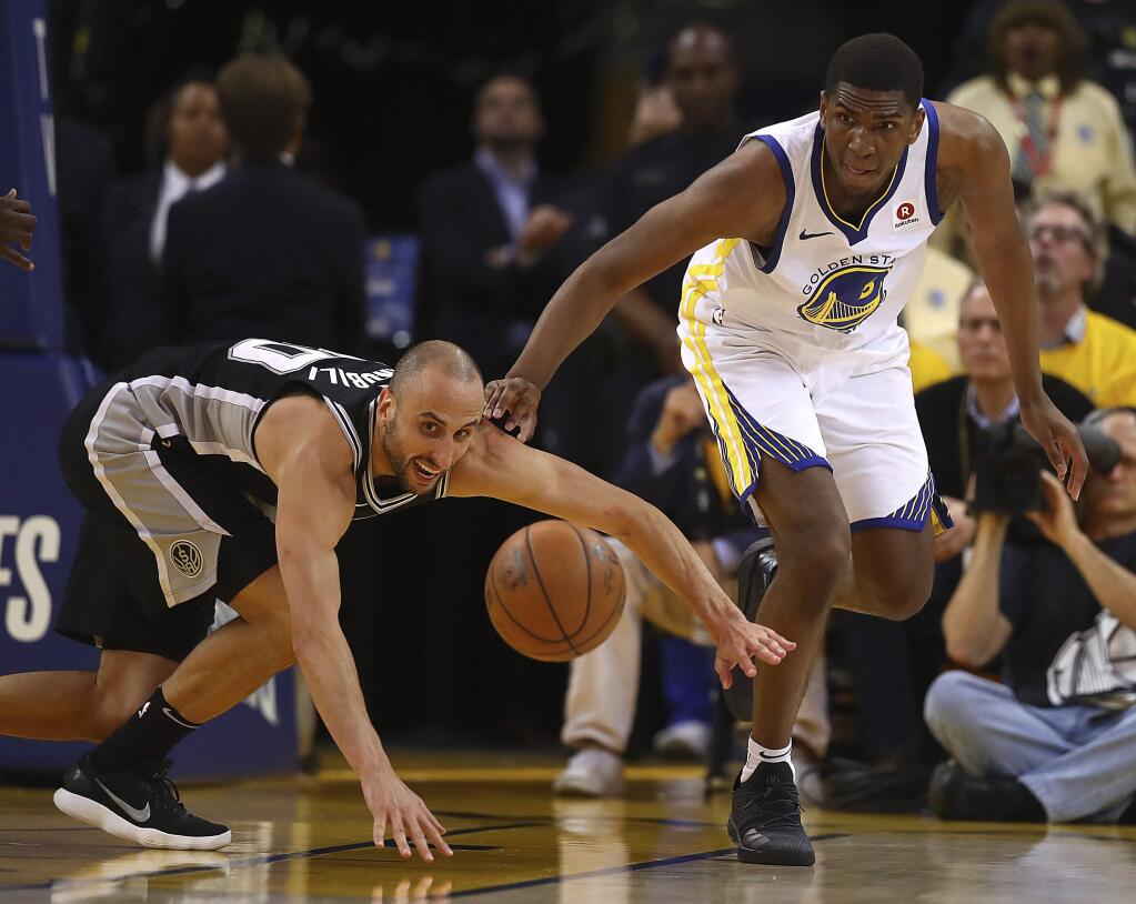 The Golden State Warriors' Kevon Looney, right, and the San Antonio Spurs' Manu Ginobili chase a loose ball during the fourth quarter in Game 5 of their first-round playoff series Tuesday, April 24, 2018, in Oakland. Golden State won 99-91. (AP Photo/Ben Margot)