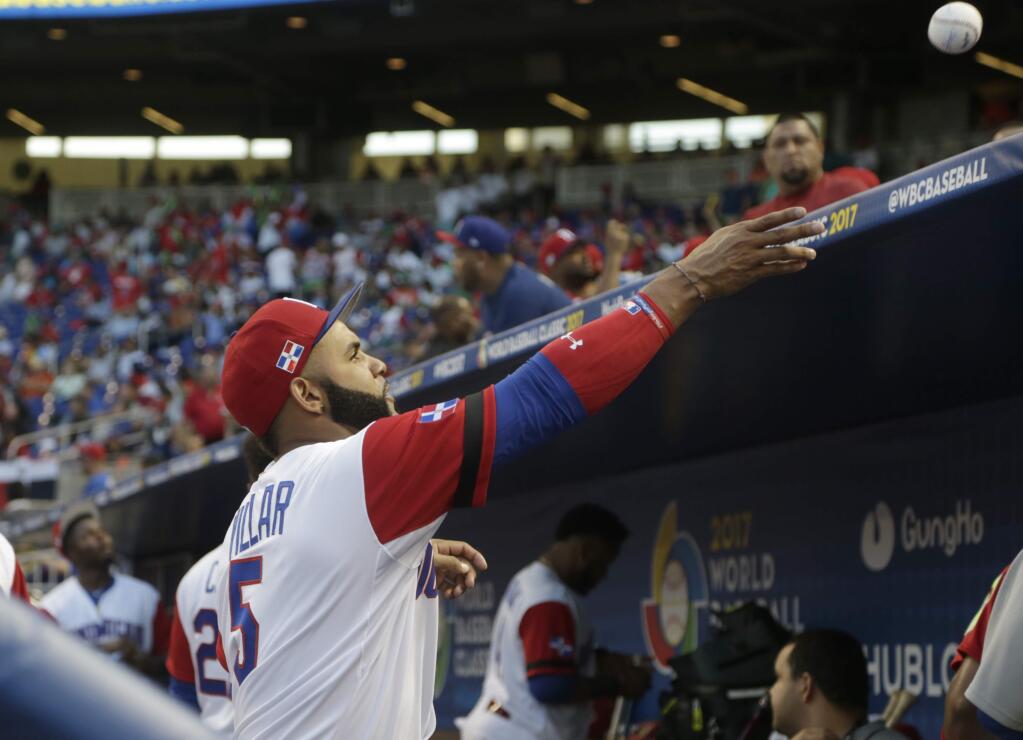 Dominican Republic infielder Jonathan Villar (5) throws a ball to a fan before a first round game of the World Baseball Classic against Canada, Thursday, March 9, 2017, in Miami. (AP Photo/Lynne Sladky)