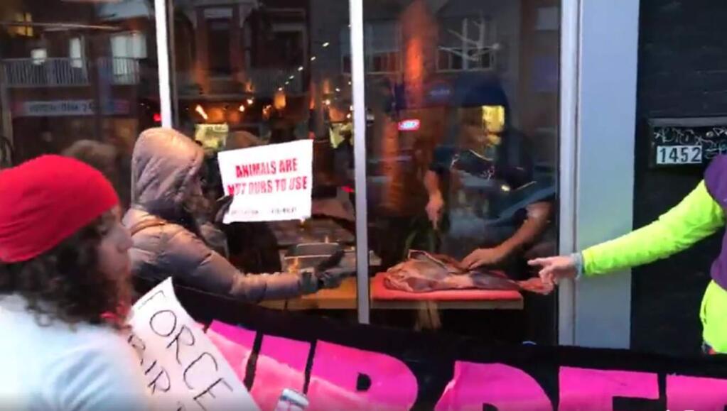 A group of animal rights activists protested in front of a busy restaurant over their meat dishes, so the chef held a counter-protest - a window-side deer carving. (VIDEO SCREENSHOT / FACEBOOK)