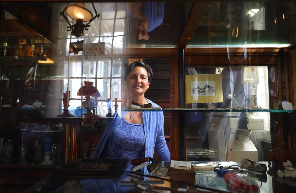 Anne Keck removes antique scrimshaw items from a display case, because they cannot be sold in California, as she prepares her parents' shop, The Wooden Duck Antique Shop, for an estate sale, in Bodega on Wednesday, August 22, 2018. Keck's parents operated the shop since 1968, but it has been closed for the past few years. The estate sale will take place this weekend, and the following weekend.(Christopher Chung/ The Press Democrat)