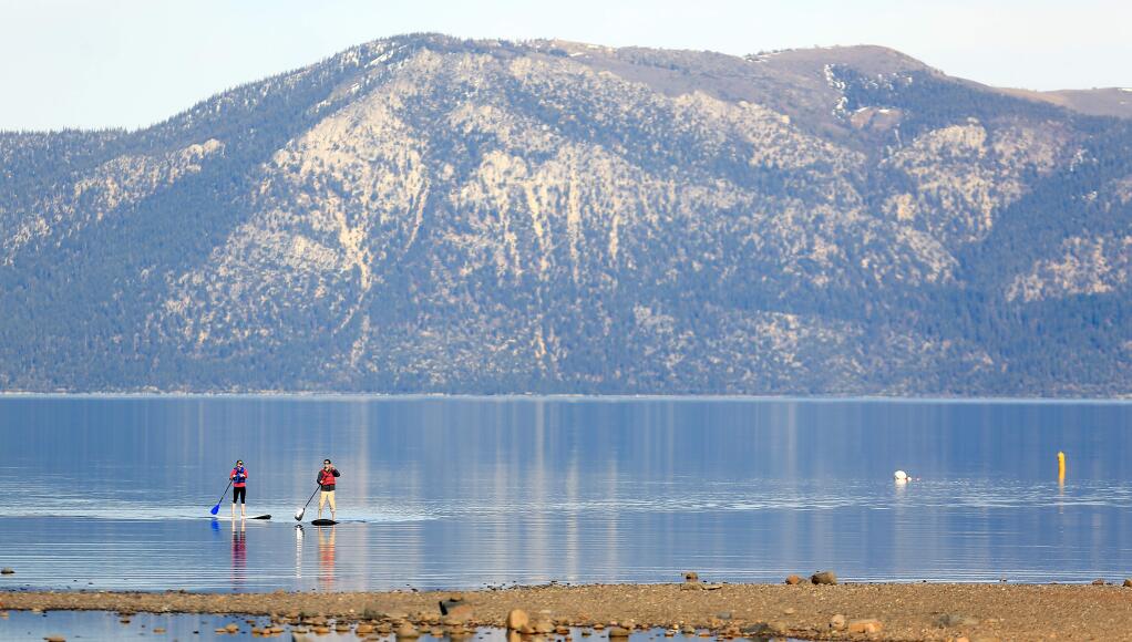 Tami Warner and Bart Srianant of Chino Hills paddle board on Lake Tahoe in Tahoe City, Wednesday March 25, 2015. A meager snowpack on mountains surrounding the lake are a reminder the California is entering a fourth year of drought. Kent Porter / Press Democrat) 2015