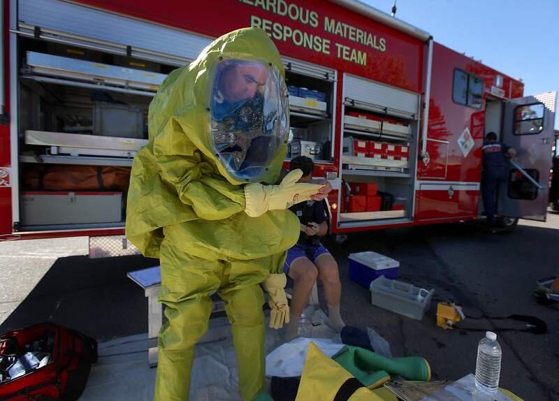 Santa Rosa firefighters Bryon Reid and Tim Aboudara don Level A hazardous materials suits prior to inspecting a chemical reaction inside Dollar Drug on College Ave. in Santa Rosa, Wednesday Sept. 28, 2011. Two employees of the drugstore were sent to the hospital as a a precaution. (Kent Porter / Press Democrat) 2011