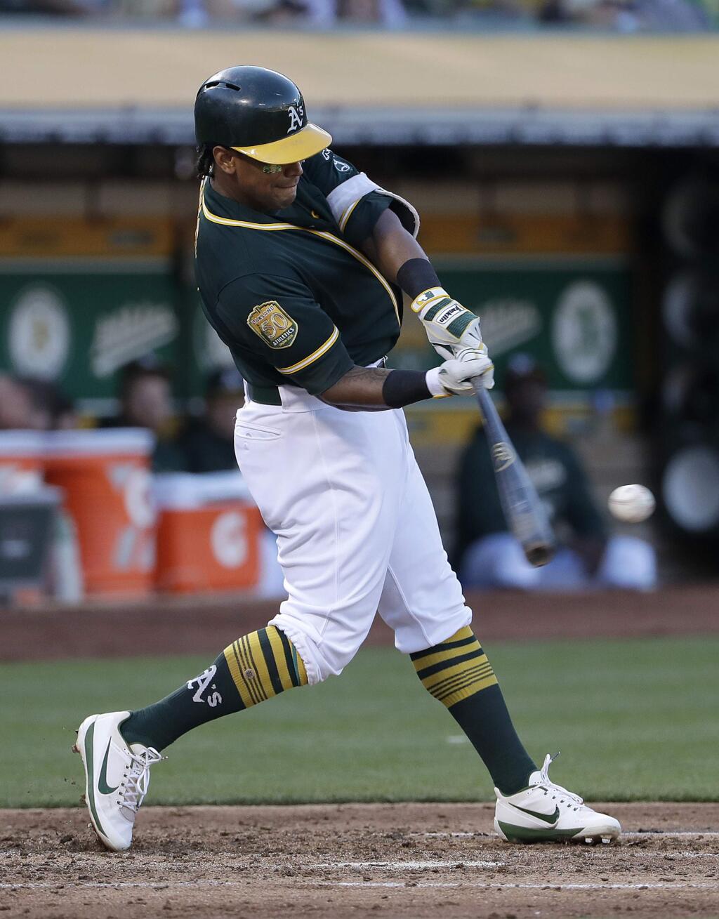 In this Aug. 4, 2018 file photo, the Oakland Athletics' Khris Davis hits a solo home run against the Detroit Tigers during the third inning of a baseball game in Oakland. (AP Photo/Jeff Chiu, File)
