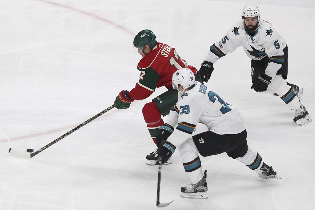 Minnesota Wild's Eric Staal (12) pushes the puck out in front of San Jose Sharks' Logan Couture (39) and David Schlemko (5) in the first period Tuesday, March 21, 2017, in St. Paul, Minn. (AP Photo/Stacy Bengs)