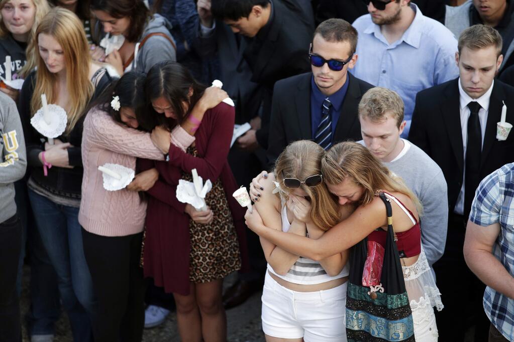 FILE - In this May 24, 2014 file photo, students comfort each other during a candlelight vigil held to honor the victims of the May 23, 2014 mass shooting on the campus of the University of California, Santa Barbara. California Assembly members have proposed AB1014, a bill allowing an immediate family member, therapist or health care provider to go directly to a judge to let law enforcement seize guns from those they deem a danger. (AP Photo/Jae C. Hong, File)