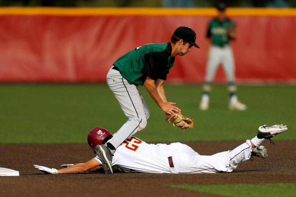 Cardinal Newman's Nick George (25) slides between the legs of Maria Carrillo's KC Kelly (22) and reaches second base safely before being tagged, during a varsity baseball game between Maria Carrillo and Cardinal Newman high schools in Santa Rosa, California, on Friday, May 10, 2019. (Alvin Jornada / The Press Democrat)