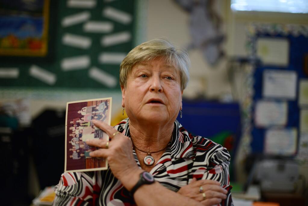 Teacher Betty Paulukonis in her 7th grade class at Willowside Middle School in Santa Rosa reminiscing about her early days teaching while holding a 1975 photo of her with the class she taught during her first year teaching. May 11, 2016. (Photo: Erik Castro/for The Press Democrat)
