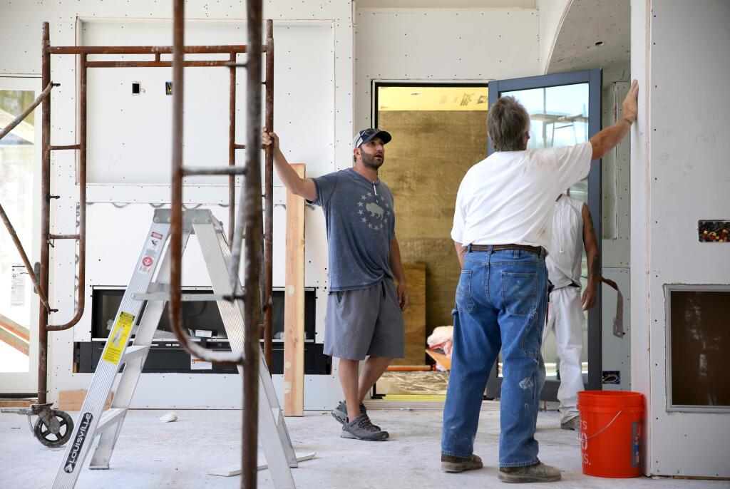 Marwan Dada talks with drywall contractors at his parent's new home on Wednesday, June 12, 2019, after their home was destroyed by the Tubbs fire. (Beth Schlanker/The Press Democrat)