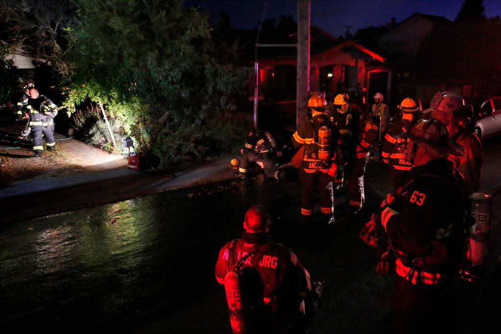 Healdsburg and Sonoma County Fire District firefighters prepare to conduct salvage operations after a fire was extinguished at a home on Sherman Street in Healdsburg on Tuesday, Sept. 3, 2019. (ALVIN JORNADA/ PD)