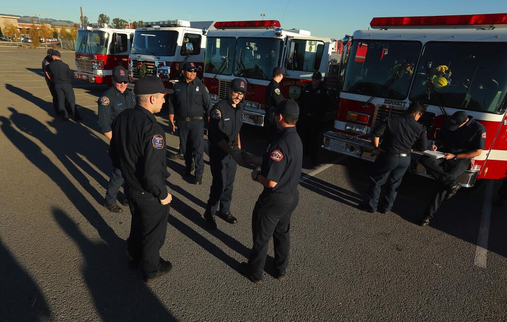 Firefighters from Bennet Valley, Santa Rosa, Gold Ridge and Petaluma meet in the parking lot at the Sonoma-Marin Fairgrounds before heading south to help combat the fires in Ventura County. (photo by John Burgess/The Press Democrat)