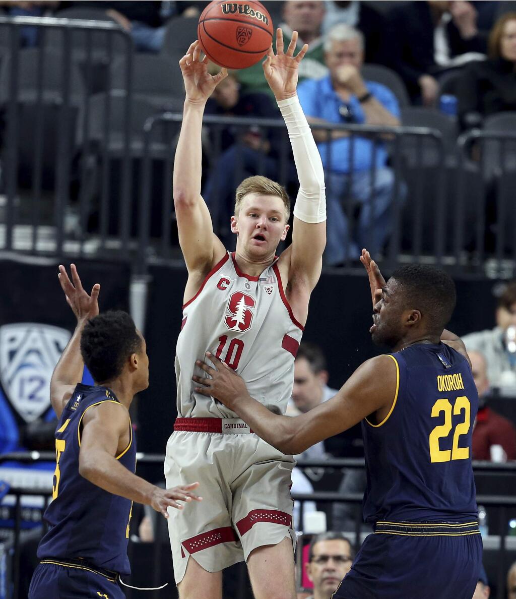 Stanford's Michael Humphrey, center, passes while covered by Cal's Roman Davis, left, and Kingsley Okoroh, right, during the first half in the first round of the Pac-12 men's tournament Wednesday, March 7, 2018, in Las Vegas. (AP Photo/Isaac Brekken)