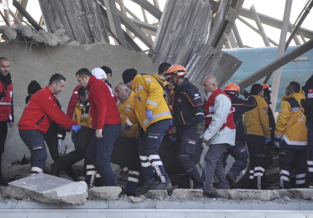 Members of rescue services assist victims at the scene of a train accident in Ankara, Turkey, Thursday, Dec. 13, 2018. A high-speed train hit a railway engine and crashed into a pedestrian overpass at the station in the Turkish capital Thursday, killing several people and injuring scores of others, officials and news reports said. (Gokhan Ceylan/DHA via AP)