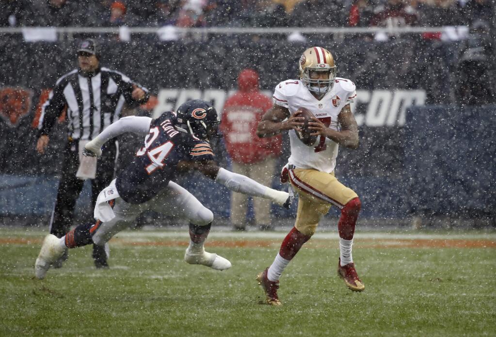 San Francisco 49ers quarterback Colin Kaepernick tries to run away from Chicago Bears outside linebacker Leonard Floyd during the first half Sunday, Dec. 4, 2016, in Chicago. (AP Photo/Charles Rex Arbogast)