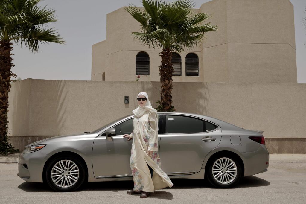 In this Sunday, June 24, 2018 photo, Ammal Farahat, who has signed up to be a driver for Careem, a regional ride-hailing service that is a competitor to Uber, poses for a photograph next to her car on a street in Riyadh, Saudi Arabia. It's the latest job opening for Saudi women that had been reserved for men only and one that sharply challenges traditional norms. (AP Photo/Nariman El-Mofty)