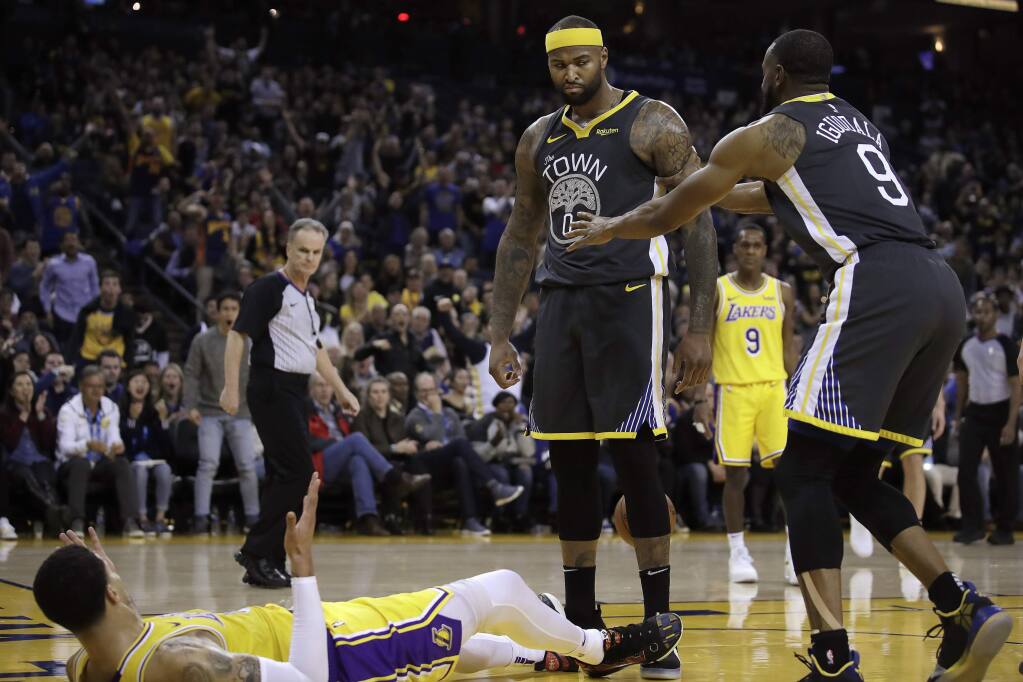 In this Feb. 2, 2019, file photo, Golden State Warriors' Andre Iguodala, right, tries to move DeMarcus Cousins, center, away from Los Angeles Lakers' Kyle Kuzma, left, during an NBA basketball game in Oakland, Calif. Cousins cannot wait for his playoff chance at last. He has anticipated this moment so many times and it never happened. That is why he approached the Warriors last summer and asked for a chance, even though he was working back from season-ending surgery for a torn left Achilles tendon. Cousins joined the two-time defending champions for $5.3 million and this very opportunity. (AP Photo/Ben Margot, File)