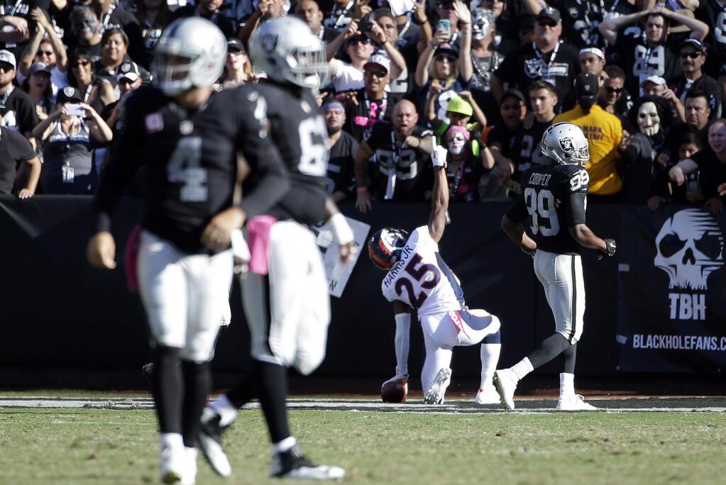 Denver Broncos cornerback Chris Harris (25) celebrates after returning an interception from Oakland Raiders quarterback Derek Carr (4) for a 74-yard touchdown during the second half of an NFL football game in Oakland, Calif., Sunday, Oct. 11, 2015. (AP Photo/Marcio Jose Sanchez)