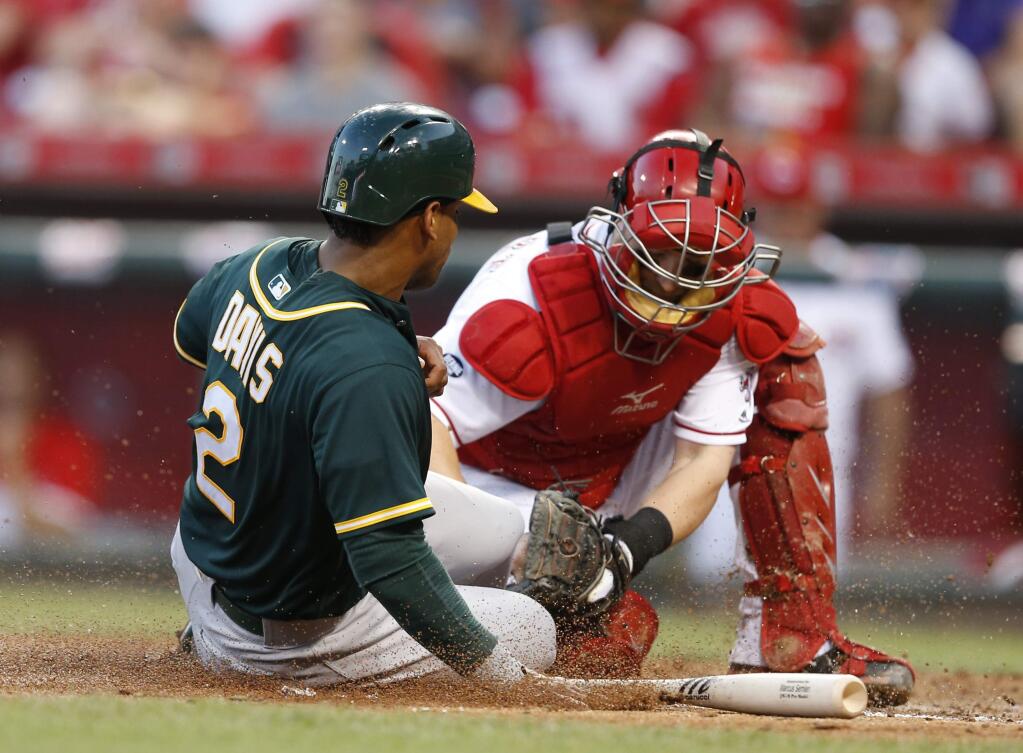 Oakland Athletics' Khris Davis (2) is tagged out at the plate, attempting to score, by Cincinnati Reds catcher Tucker Barnhart during the sixth inning Friday, June 10, 2016, in Cincinnati. (AP Photo/Gary Landers)