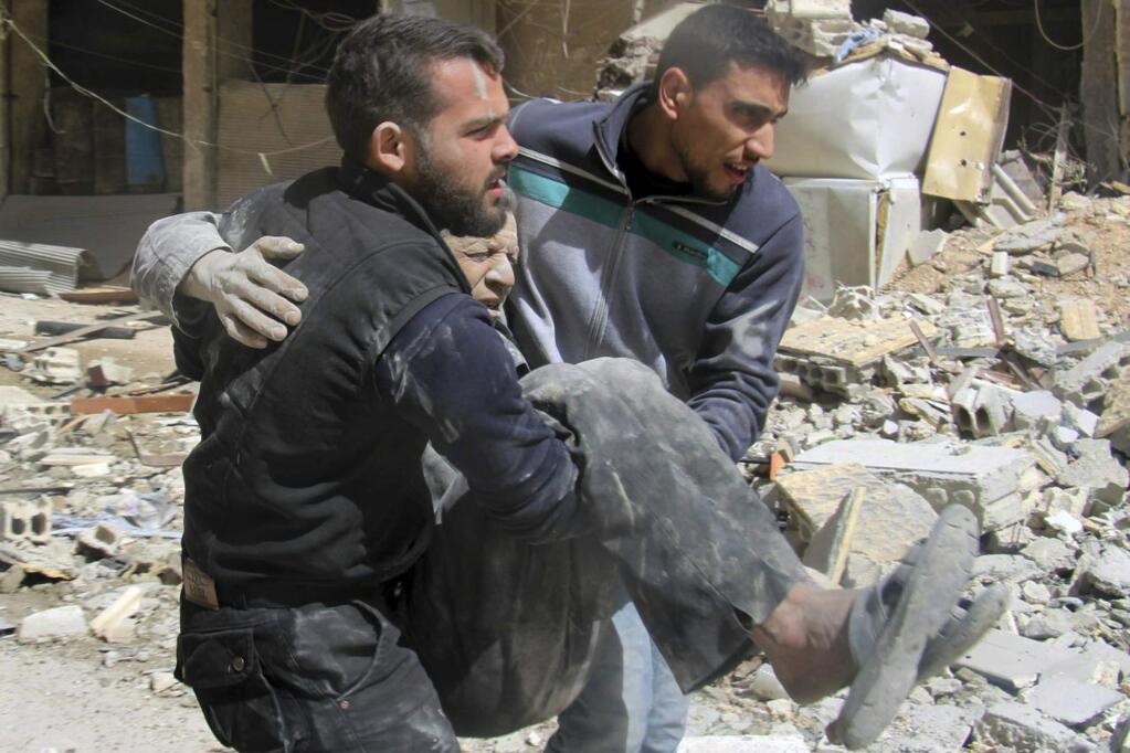 This photo released by the Syrian Civil Defense White Helmets, which has been authenticated based on its contents and other AP reporting, shows members of the White Helmets carrying a man who was wounded after airstrikes and shelling hit in Arbeen, in the eastern Ghouta region near Damascus, Syria, Tuesday, March. 20, 2018. The U.N. refugee agency says 45,000 Syrians have left their homes in the besieged region of eastern Ghouta in recent days, amid a Syrian government-led offensive against the rebel-held area. (Syrian Civil Defense White Helmets via AP)