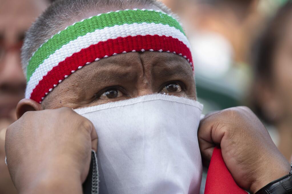 A Mexico fan covers his face as he watches the Mexico vs. Germany World Cup soccer match on an outdoor screen in Mexico City's Zocalo, Sunday, June 17, 2018. Mexico won it's first match against Germany 1-0. (AP Photo/Anthony Vazquez)