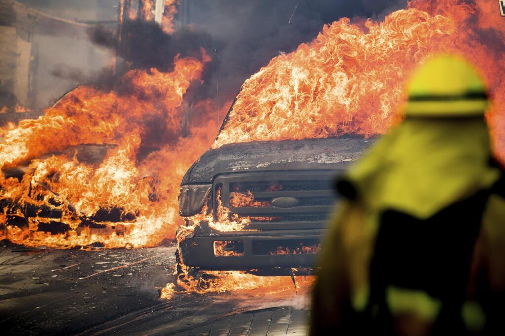 Flames consume vehicles as a wildfire rages in Ventura, Calif., on Tuesday, Dec. 5, 2017. (AP Photo/Noah Berger)