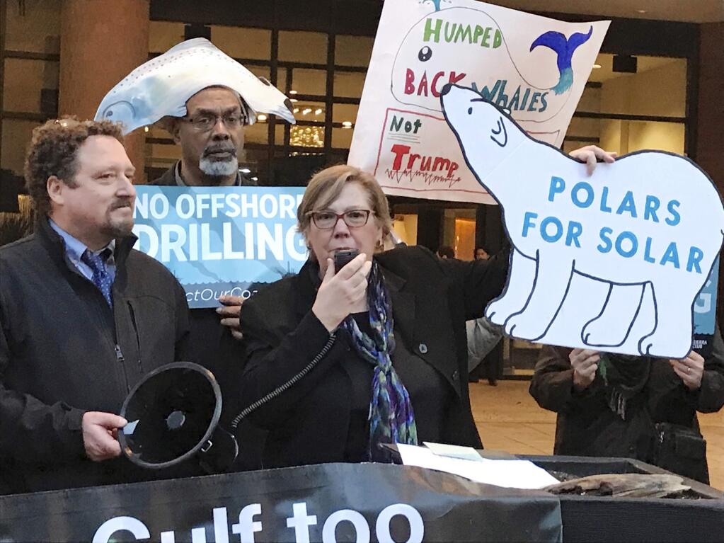 FILE - In this Feb. 15, 2018 file photo, Judith Enck, center, former regional administrator for the Environmental Protection Agency addresses those gathered at a protest against President Trump's plan to expand offshore drilling for oil and gas in Albany, N.Y. A U.S. judge in Alaska says President Donald Trump exceeded his authority when he reversed a ban on offshore drilling in vast parts of the Arctic Ocean and dozens of canyons in the Atlantic Ocean. Judge Sharon Gleason in a ruling late Friday, March 29, 2019 threw out Trump's executive order that overturned the ban implemented by President Barack Obama.(AP Photo/David Klepper, File)