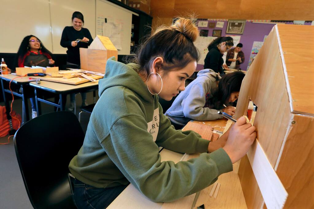 Roseland University Prep junior Yanet Flores creates window trim for a model of a new home out of wood for their maker class teacher Anna Solano, who lost her home in Coffey Park in the Tubbs fire. (Photo by John Burgess/The Press Democrat)