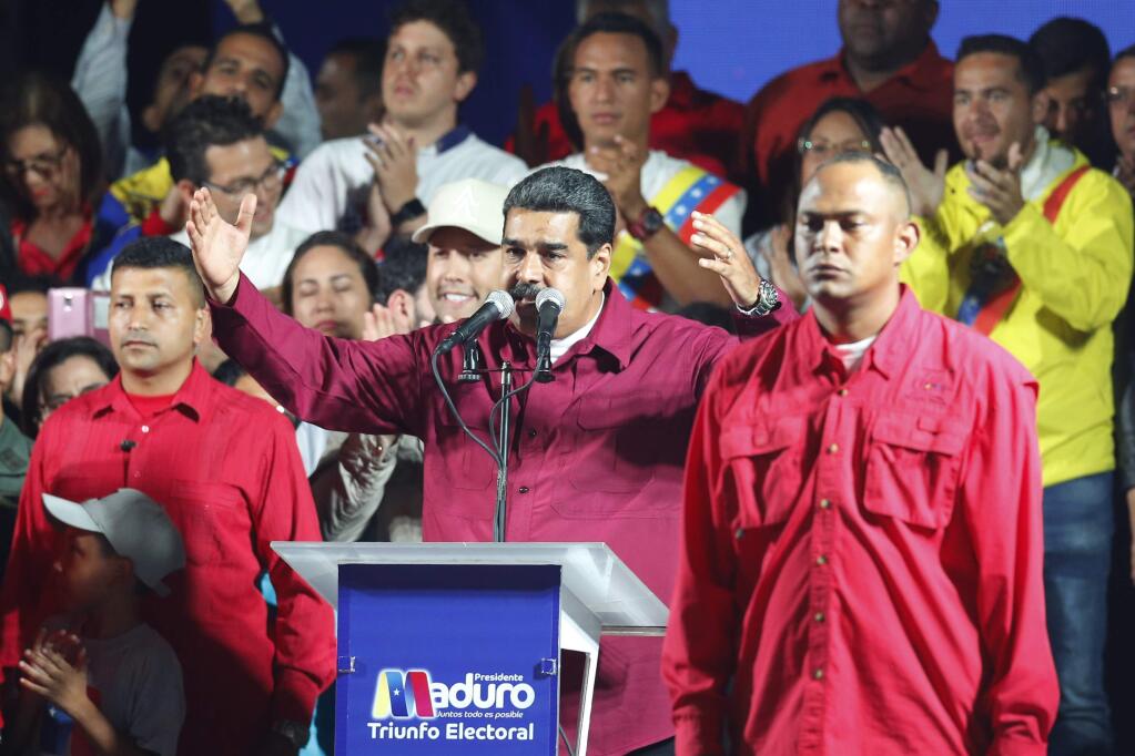 Venezuela's President Nicolas Maduro addresses supporters after the National Electoral Council said he was re-elected for a second six-year term at the presidential palace in Caracas, Venezuela, Sunday, May 20, 2018. (AP Photo/Ariana Cubillos)