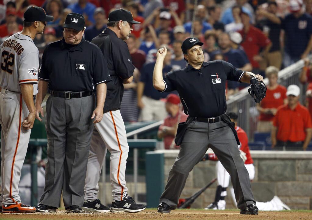 Home plate umpire Phil Cuzzi, right, ejects San Francisco Giants manager Bruce Bochy, second from right, after ejecting starting pitcher Ryan Vogelsong (32), as umpire Gerry Davis, second from left, stands nearby, during the fifth inning of a game against the Washington Nationals at Nationals Park, Sunday, July 5, 2015, in Washington. (AP Photo/Alex Brandon)