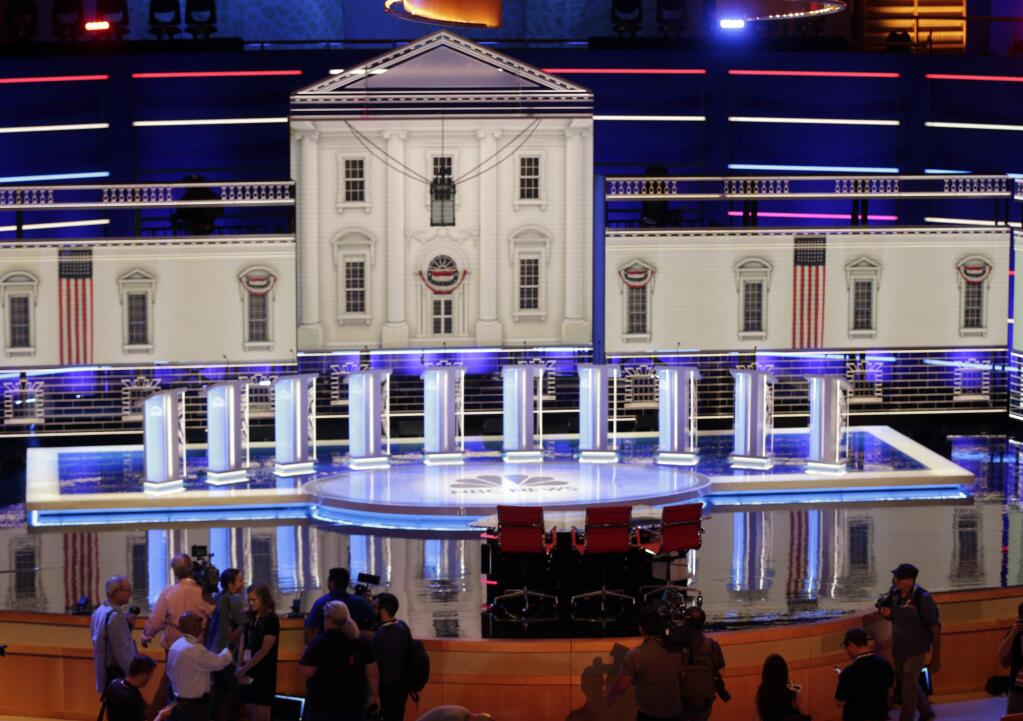 Members of the media gather for a walk-through of the stage set-up for the first democratic debate, Wednesday, June 26, 2019. Ten presidential candidates, led by Sen. Elizabeth Warren, are set to converge on the debate stage on the first night of Democratic debates to offer their pitches to the American people and attempt a breakout moment for their campaigns. (AP Photo/Marta Lavandier)