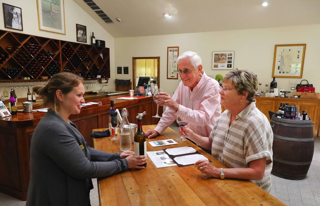 Alexander Valley Vineyards director of hospitality Kristy Ramirez, left, talks to George and Sandy Reay, from Lake Oswego, Oregon, as they sample the Alexander Valley Vineyards 2016 Wine Club Reserve, in Healdsburg on Tuesday, August 21, 2018. (Christopher Chung/ The Press Democrat)