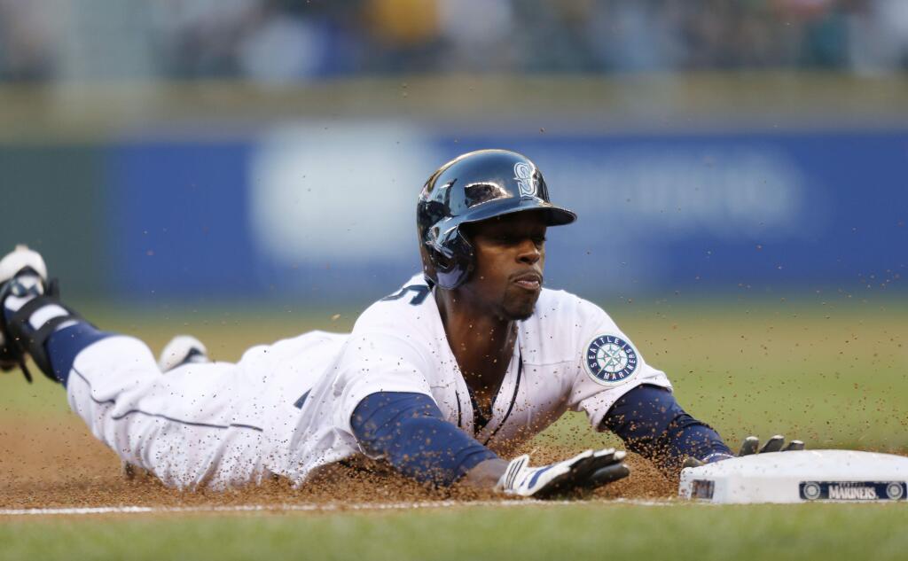 Seattle Mariners' James Jones dives into third for a triple against the Oakland Athletics during the third inning of a baseball game on Saturday, Sept. 13, 2014, in Seattle. Jones went on to score. (AP Photo/John Froschauer)