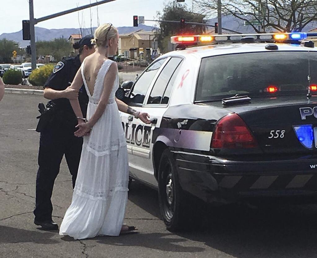 This photo provided by the Marana Police Department, in Arizona, shows 32-year-old Amber Young during her arrest on suspicion of impaired driving, Monday, March 12, 2018, in southern Arizona. Police say Young became involved in a car crash in Marana as she was driving to her wedding. One person suffered minor injuries in the three-vehicle crash. (Marana Police Department via AP)