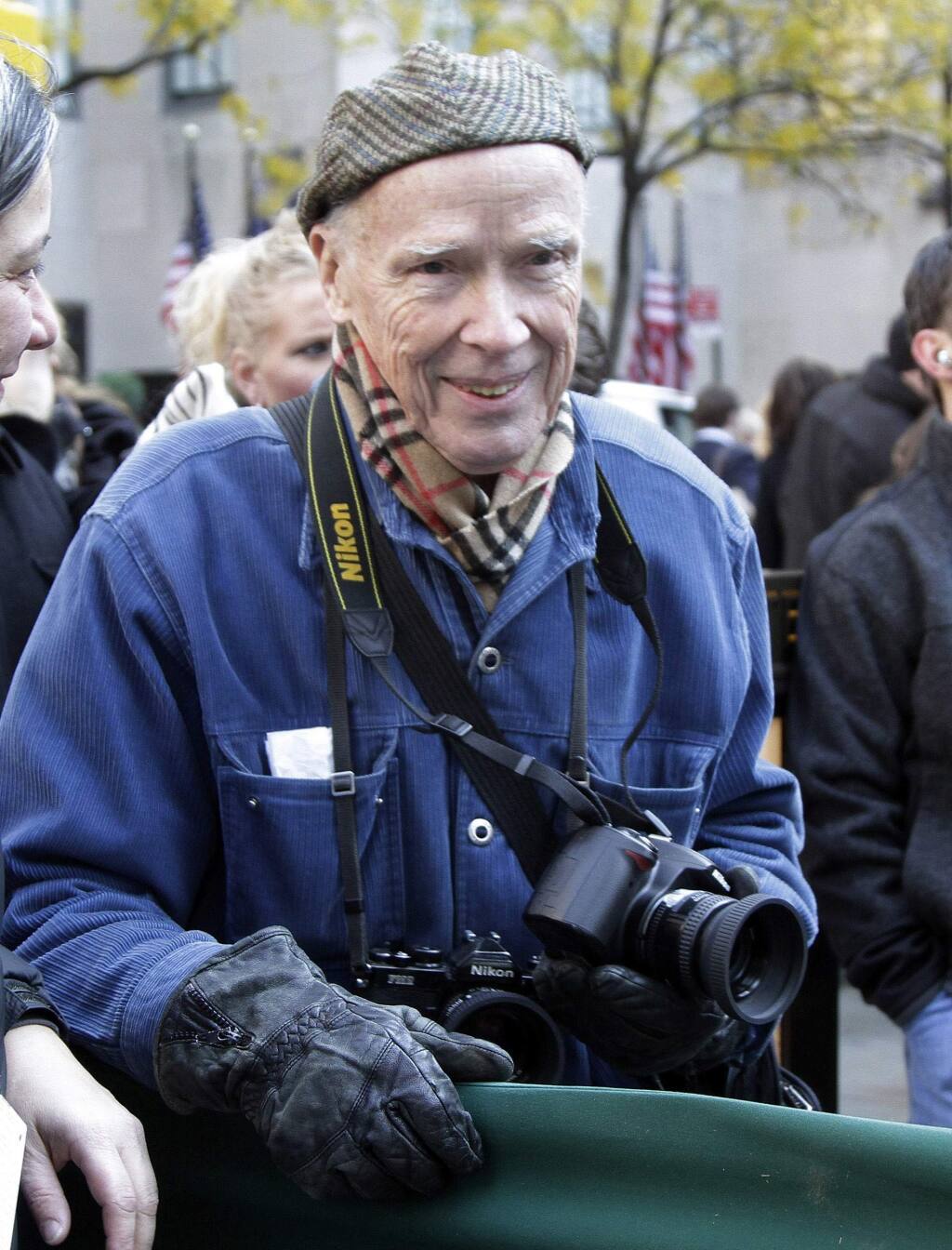 FILE - In this Nov. 11, 2011 file photo, New York Times photographer Bill Cunningham waits for the arrival of the annual Rockefeller Center Christmas tree, in New York. Cunningham, a longtime fashion photographer for The New York Times known for taking pictures of everyday people on the streets in New York died on Saturday, June 25, 2016, after suffering a stroke in New York. He was 87. (AP Photo/Richard Drew, File)