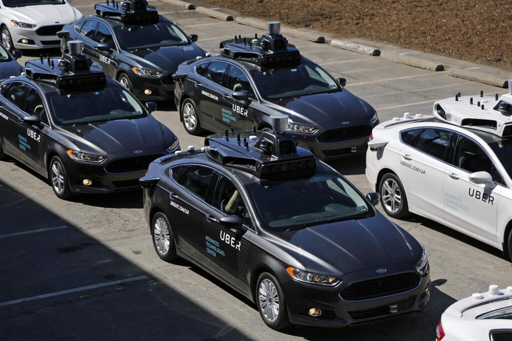 FILE- This Sept. 12, 2016, file photo, shows group of self driving Uber vehicles position themselves to take journalists on rides during a media preview at Uber's Advanced Technologies Center in Pittsburgh. Uber is settling a lawsuit filed by Google's autonomous car unit alleging that the ride-hailing service ripped off self-driving car technology. Both sides in the case issued statements confirming the settlement Friday, Feb. 9, 2018, morning in the midst of a federal court trial in the case. (AP Photo/Gene J. Puskar, File)