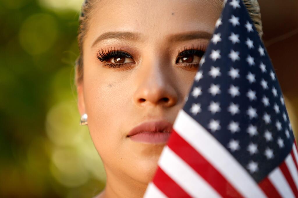 Amalia Montes, 26, a Dreamer enrolled in the Delayed Action for Childhood Arrivals (DACA) program, poses for a portrait with an American flag that was displayed at her home, in Santa Rosa, California on Tuesday, September 5, 2017. Montes came to the United States at age 15, with her mother and younger sister. (Alvin Jornada / The Press Democrat)