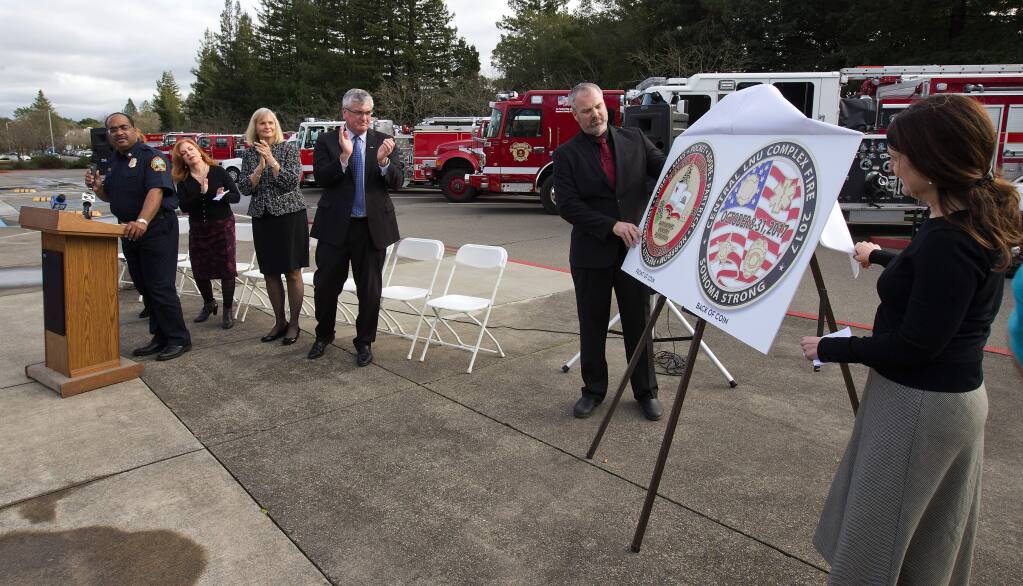 Sonoma County Board of Supervisors unveil a drawing of a 'Challenge Coin' to recognize first responders who worked during the October wildfires at a ceremony in front of the supervisors chamber in Santa Rosa on Tuesday. (photo by John Burgess/The Press Democrat)