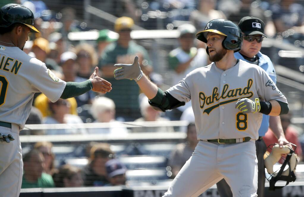 The Oakland Athletics' Jed Lowrie, right, gets congratulations from Marcus Semien after hitting a two-run home run against the San Diego Padres during the eighth inning in San Diego, Wednesday, June 20, 2018. (AP Photo/Alex Gallardo)