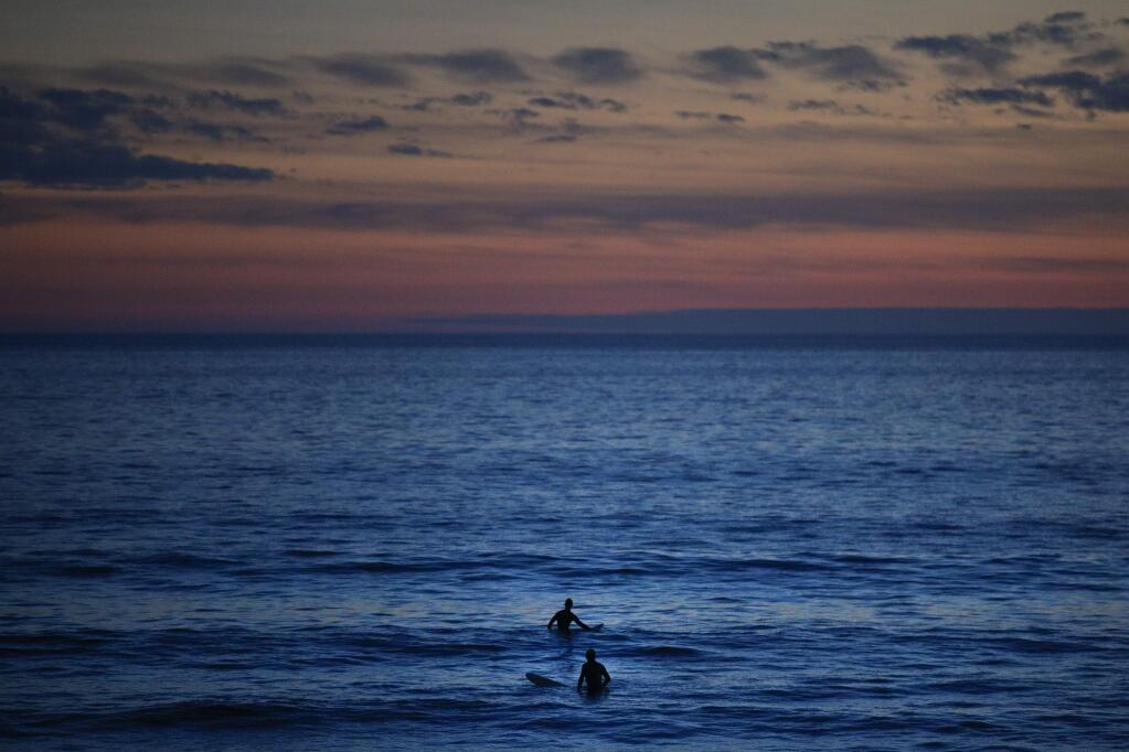 Two surfers wait for a wave in the Pacific Ocean at Sunset Beach in Pacific Palisades, Calif., Thursday, Jan. 4, 2018. (AP Photo/Jae C. Hong)