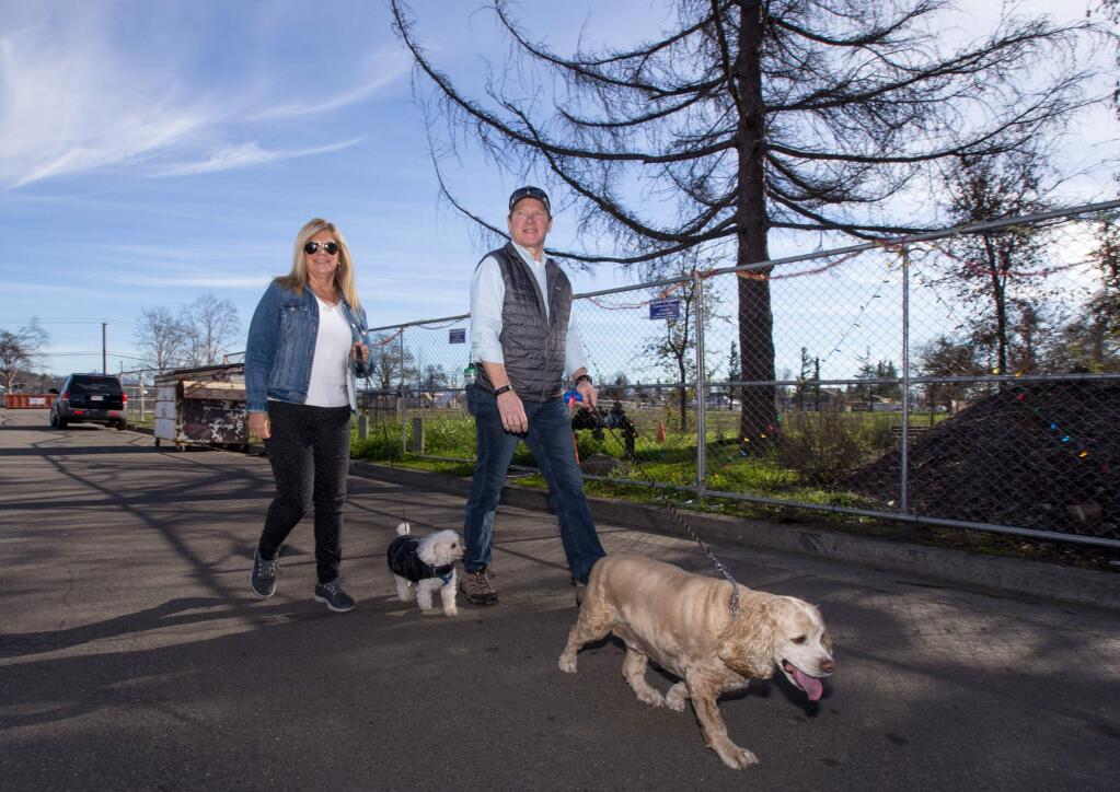 Santa Rosa Mayor Tom Schwedhelm, and wife, Jackie Schwedhelm, walk their dogs, 'Dwight' a cocker spaniel, and 'Buddy' a teacup poodle, outside the perimeter of Coffey Park, in Santa Rosa, on Saturday, December 29, 2018. Coffey Park is fenced off due to damage from the fires. (Photo by Darryl Bush / For The Press Democrat)