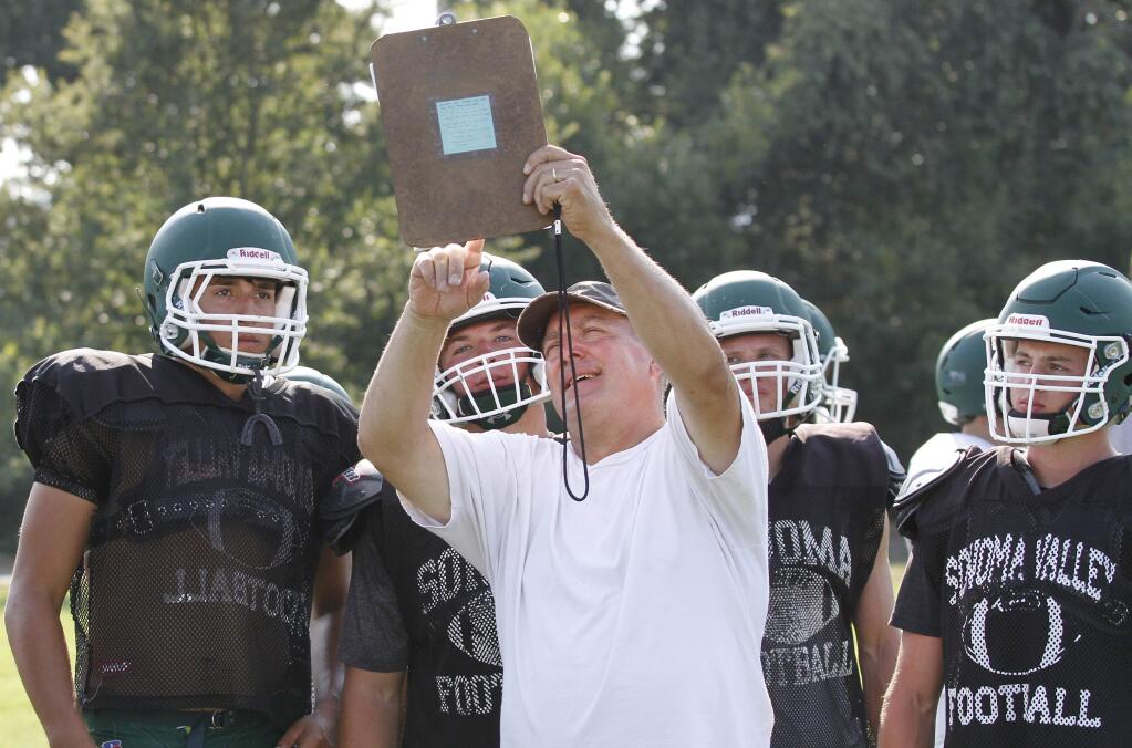 Sonoma Valley High football coach Bob Midgley holds up a clipboard at a 2017 practice to show his offense which play he wants them to run next. (Bill Hoban/Index-Tribune)