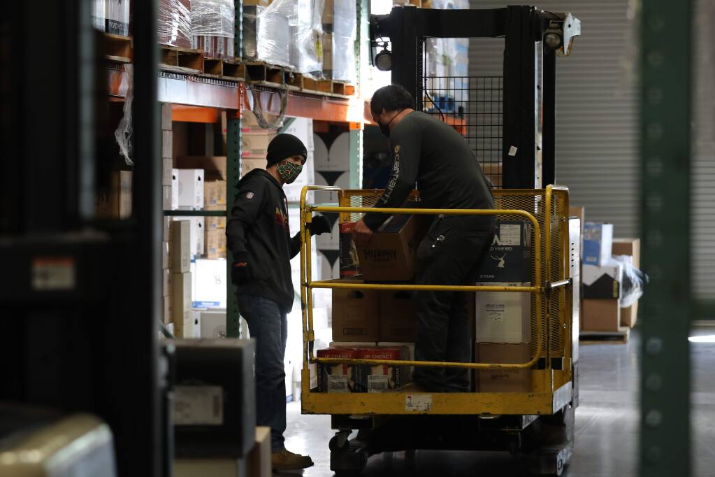 Oliver's Market warehouse employees Nicholas Hill, left, and Cody Harrington fill orders at the warehouse in Santa Rosa, California on Tuesday, April 14, 2020. (BETH SCHLANKER/ The Press Democrat)