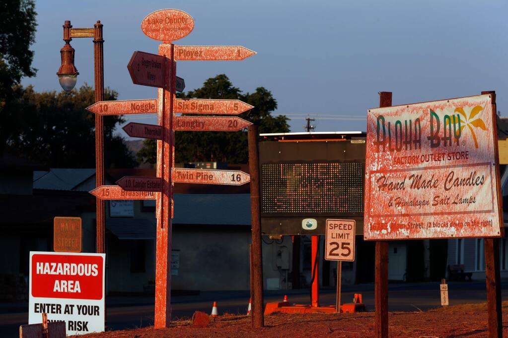 The pink hue of fire retardant still coats road signs on the corner of Main Street and Highway 29 in Lower Lake, California on Friday, August 19, 2016. (Alvin Jornada / The Press Democrat)
