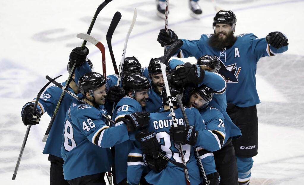San Jose Sharks' Logan Couture, bottom center, is mobbed by teammates after scoring against the Vegas Golden Knights during overtime Thursday, March 22, 2018, in San Jose. San Jose won 2-1. (AP Photo/Marcio Jose Sanchez)