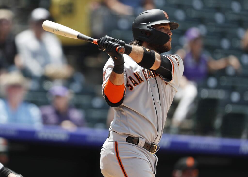 San Francisco Giants' Brandon Crawford follows the flight of his two-run home run off Colorado Rockies relief pitcher Jesus Tinoco in the sixth inning of a baseball game Monday, July 15, 2019, in Denver.(AP Photo/David Zalubowski)