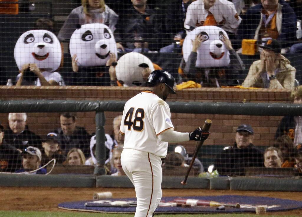 This Oct. 25, 2014, file photo shows San Francisco Giants' Pablo Sandoval walking past fans wearing panda heads after he strikes out during the third inning of Game 4 of baseball's World Series against the Kansas City Royals in San Francisco. With Sandoval's departure to the Boston Red Sox this week, Giants fan Sam Li says he and his friends have decided they must find a new way to honor their home team than those heads honoring the third baseman's 'Kung Fu Panda' nickname.(AP Photo/Charlie Riedel, File)