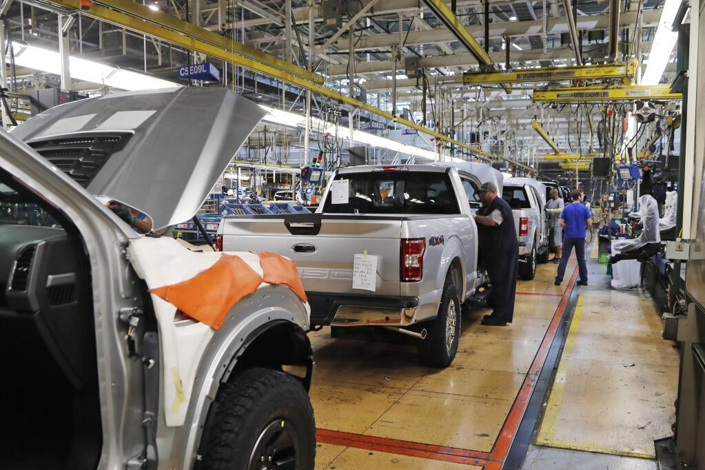 FILE - In this Sept. 27, 2018, file photo a United Auto Workers assemblymen work on a 2018 Ford F-150 trucks being assembled at the Ford Rouge assembly plant in Dearborn, Mich. The United Auto Workers union wants Detroit's three automakers to shut down their factories for two weeks to keep its members safe from the spreading coronavirus. But union President Rory Gamble says in an email to members obtained by The Associated Press that the companies were not willing to shut factories down. (AP Photo/Carlos Osorio, File)