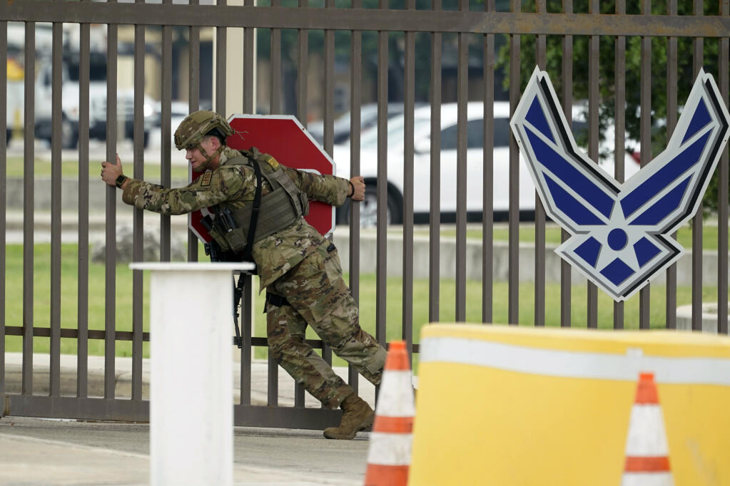 A military policeman closes a gate at JBSA-Lackland Air Force Base gate, Wednesday, June 9, 2021, in San Antonio. The Air Force was put on lockdown as police and military officials say they searched for two people suspected of shooting into the base from outside. (AP Photo/Eric Gay)
