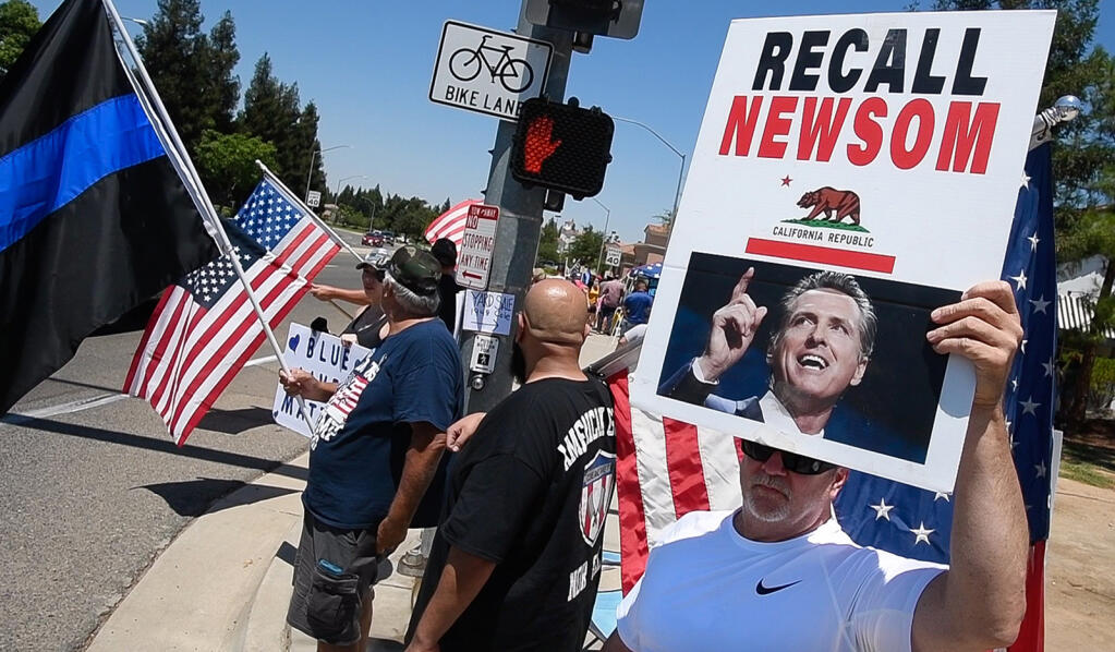 Supporters of a recall campaign targeting Gov. Gavin Newsom gathered on a Fresno street in July. (JOHN WALKER / Fresno Bee)